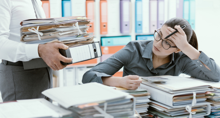woman surrounded by stacks of work